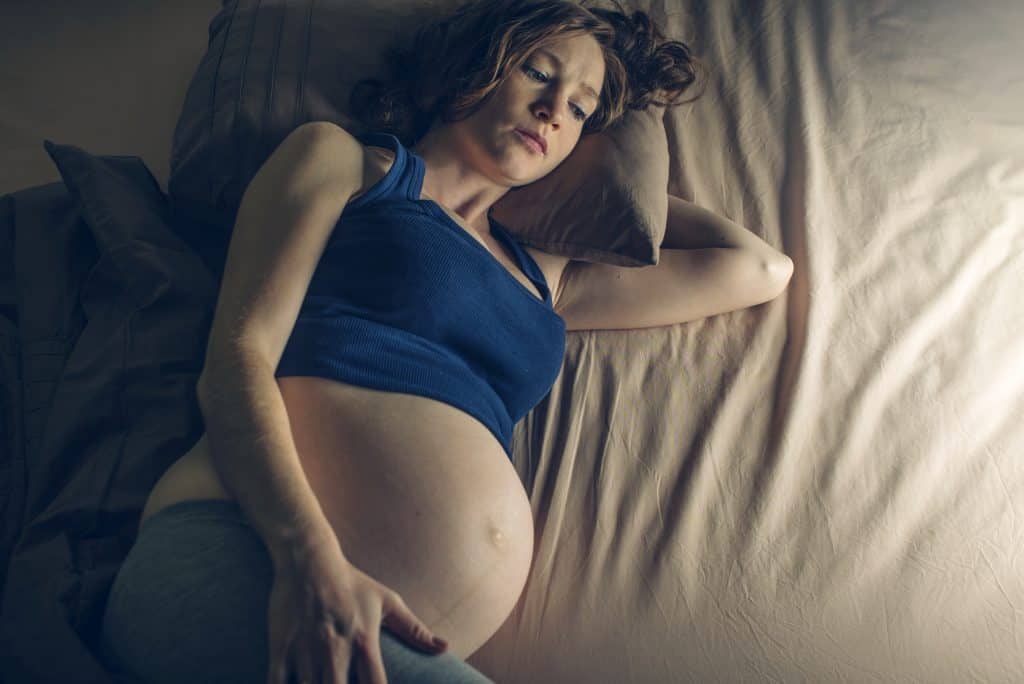 Woman having difficulty sleeping due to pregnancy 