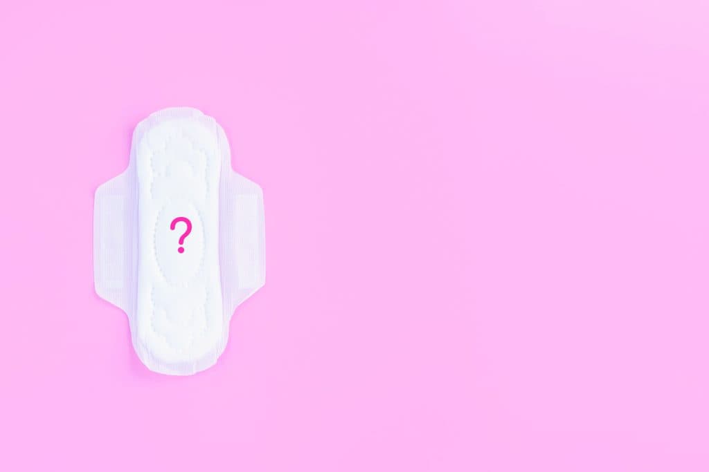 Perimenopause - pad with question mark on a pink background