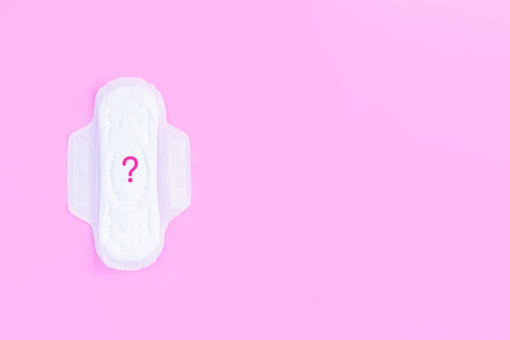 Perimenopause - pad with question mark on a pink background