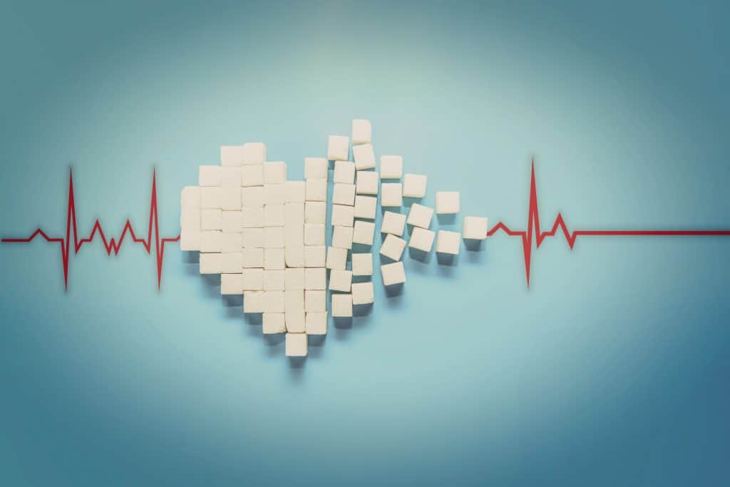 A heart symbol constructed of sugar cubes on a blue background.