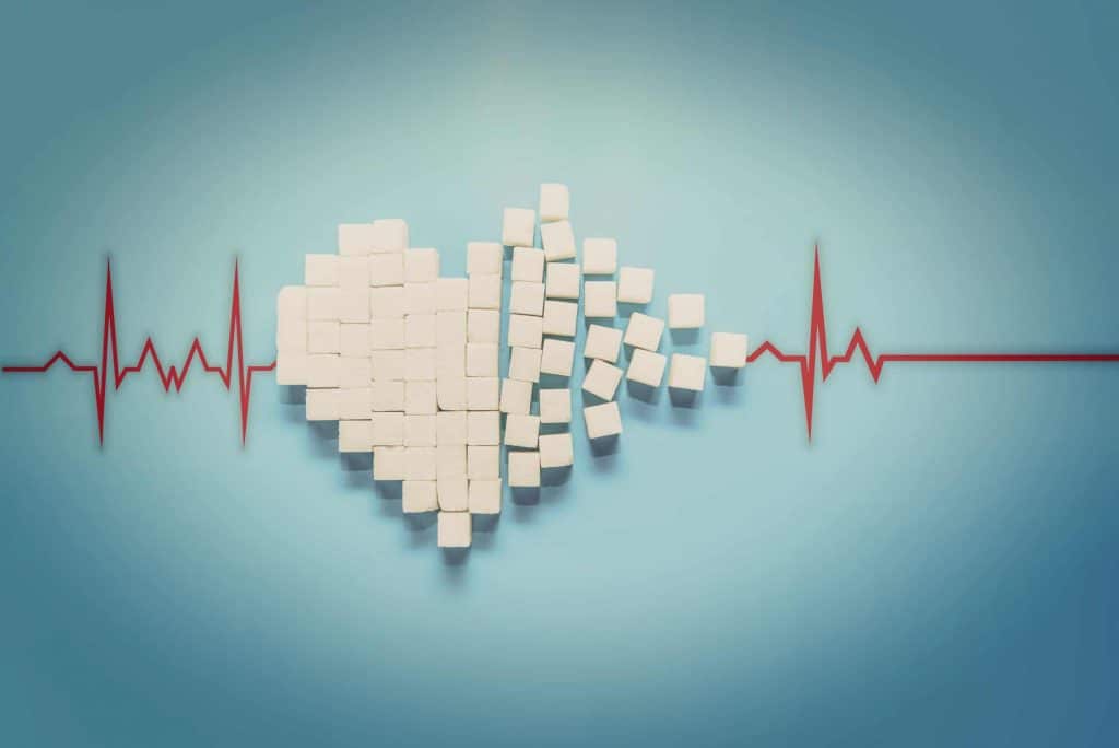 A heart symbol constructed of sugar cubes on a blue background.